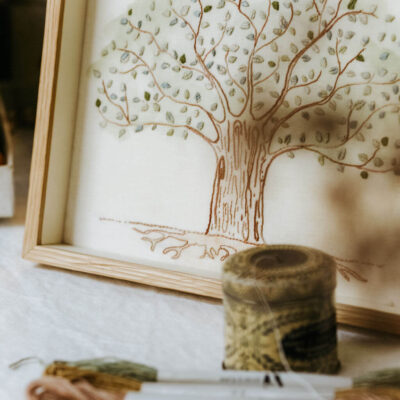 Persona bordando Árbol de la Vida con kit completo en mesa