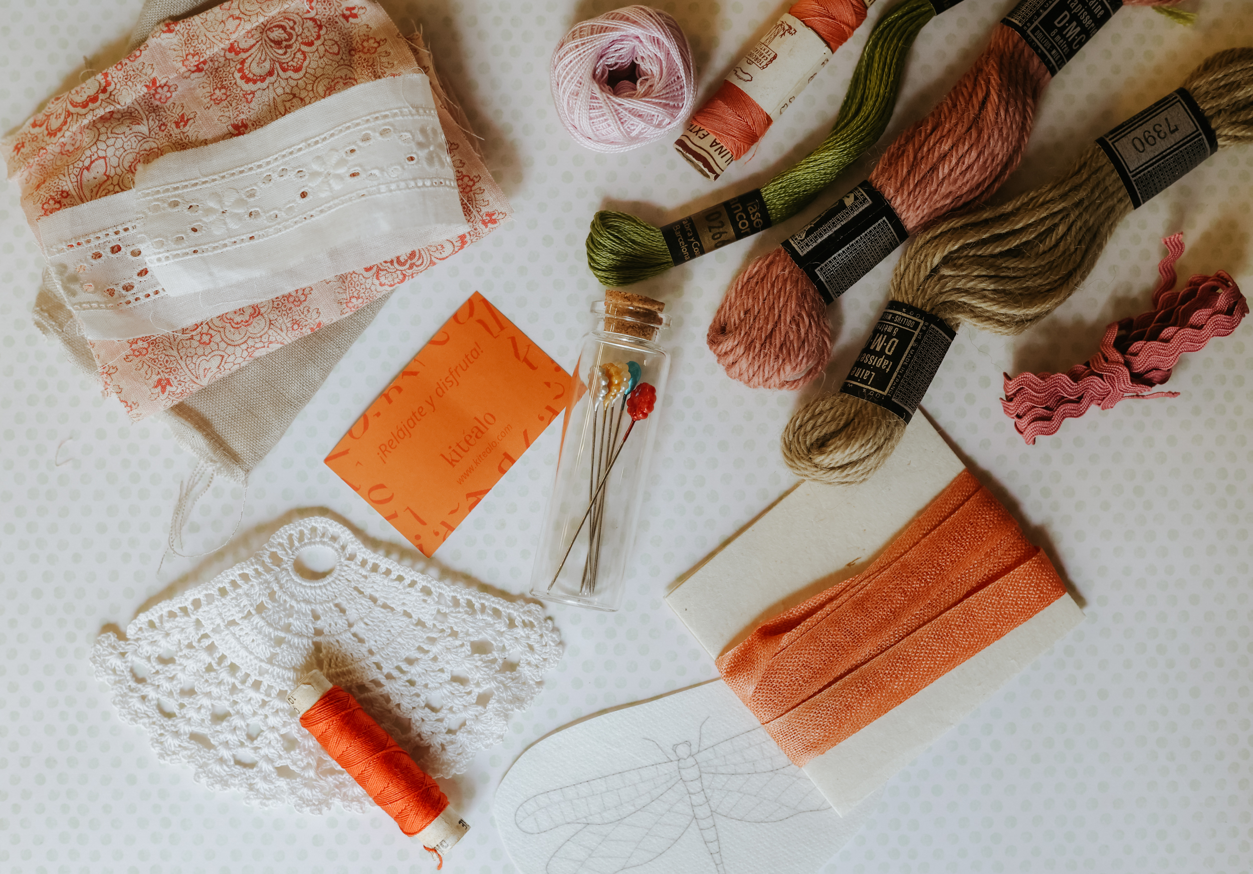 Primer plano de hilos, puntillas y pequeños materiales textiles antiguos para bordado creativo.